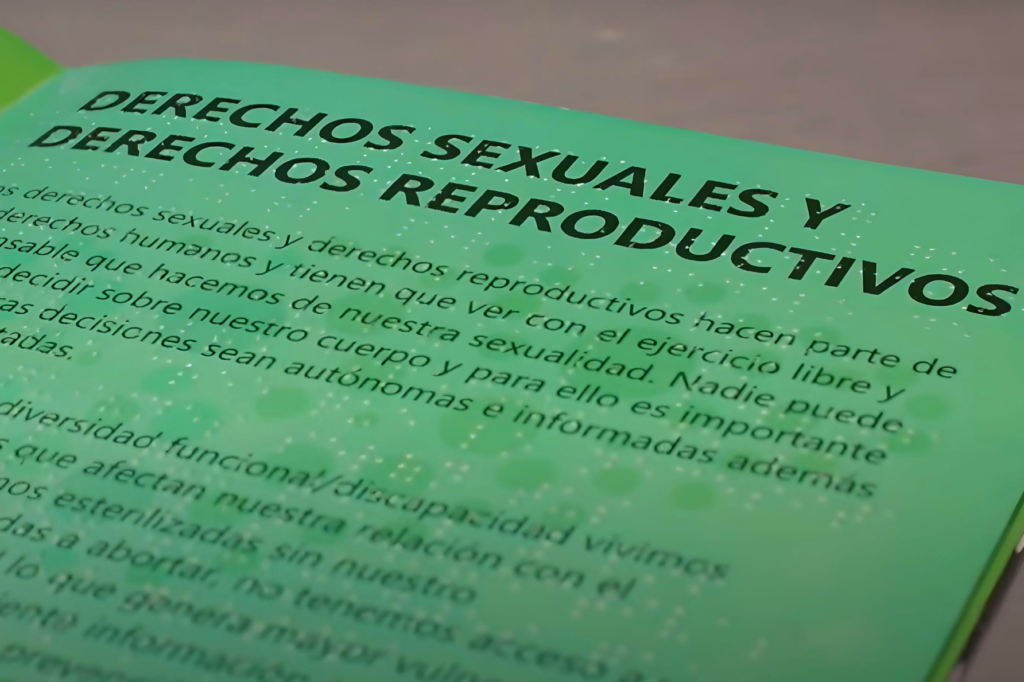 Cartilla color verde en el que se ve un título que dice “derechos sexuales y derechos reproductivos”. En relieve se muestra su correspondencia en sistema Braille.